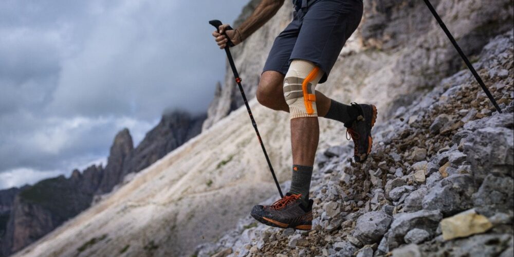 Wanderer in den Bergen geht mit der Bauerfeind Kniebandage bergab