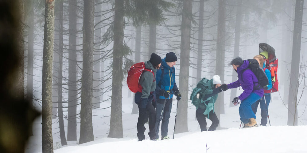 Eine Gruppe Winterwanderer im verschneiten Wald